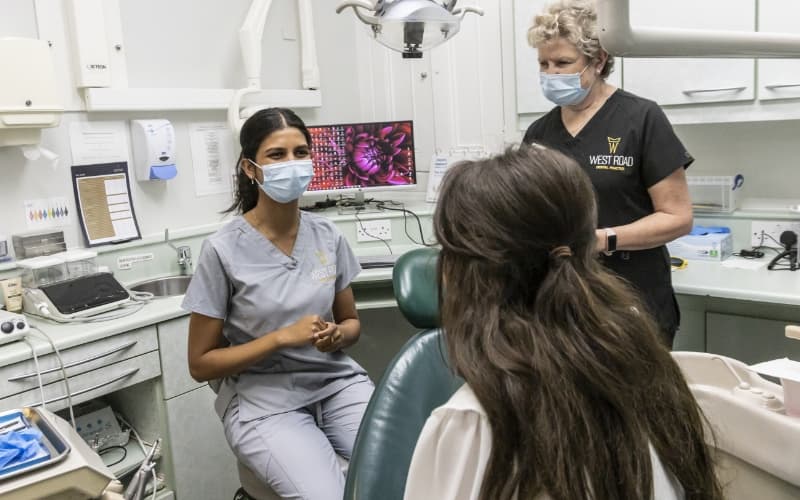 A dentist and nurse carrying out a check-up on a patient in the treatment chair