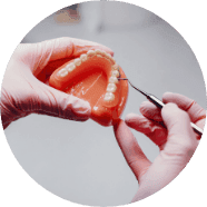 A clinician demonstrating orthodontic braces on a model of the teeth
