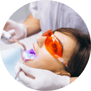 A patient in protective orange eyewear undergoing a whitening treatment