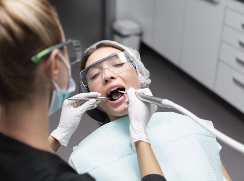 A dentist and assistant carrying out treatment on a patient in the surgery